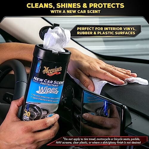 Person using car cleaning wipes on dashboard.