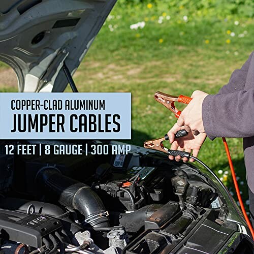 Person using jumper cables on a car engine.