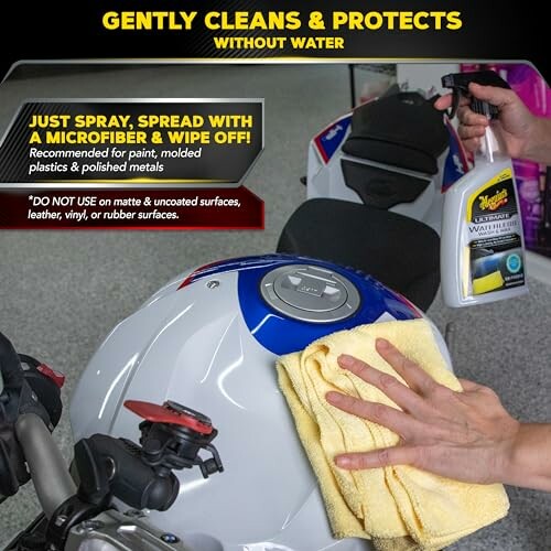 Person cleaning motorcycle with spray and microfiber cloth.