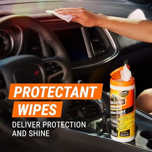 Person cleaning car dashboard with protectant wipes.